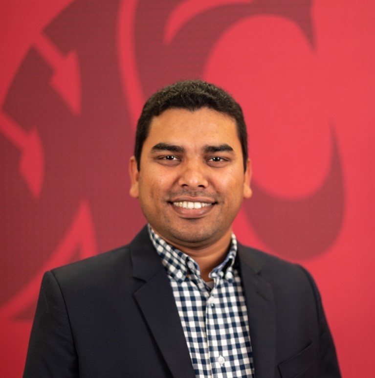 A person in a suit smiling

Description automatically generated