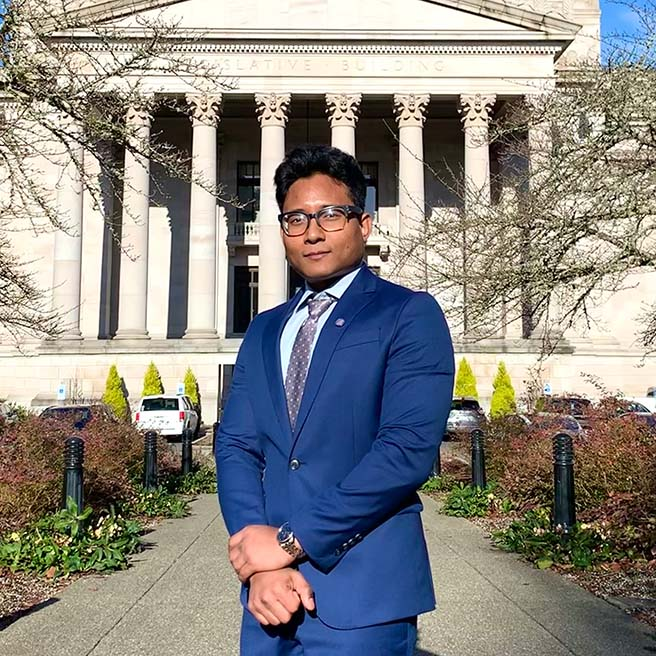 A person in a blue suit standing in front of a building

AI-generated content may be incorrect.