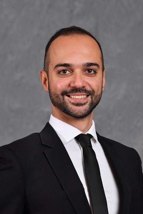 A person in a suit and tie

AI-generated content may be incorrect.